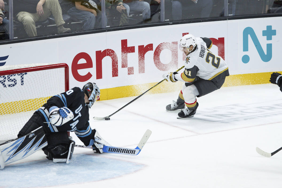 Vegas Golden Knights center Brett Howden (21) moves the puck against Utah Hockey Club goaltende ...