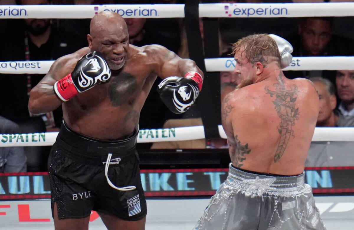 Mike Tyson, left, fights Jake Paul during their heavyweight boxing match, Friday, Nov. 15, 2024 ...