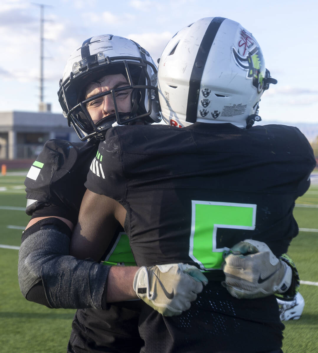 SLAM Academy linebacker Kyler Proudfoot, left, hugs sophomore Dereon Johnson, right, after winn ...