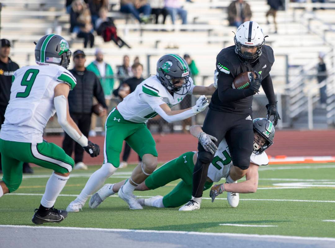 Churchill County junior Carson Melendy, bottom, attempts to tackle SLAM Academy sophomore Kaleb ...