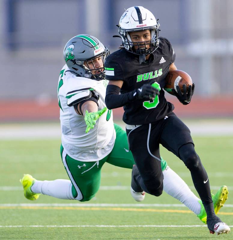 SLAM Academy senior Choy'ce Meloncon, right, avoids Churchill County junior Joseph Romero (61), ...