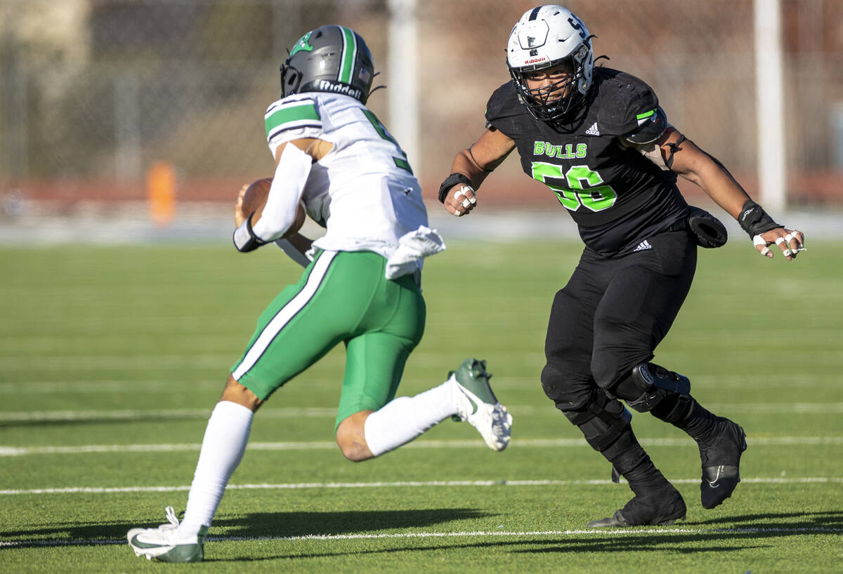 SLAM Academy senior Chenney Chua (56) looks to tackle Churchill County junior Matthew Bird, lef ...