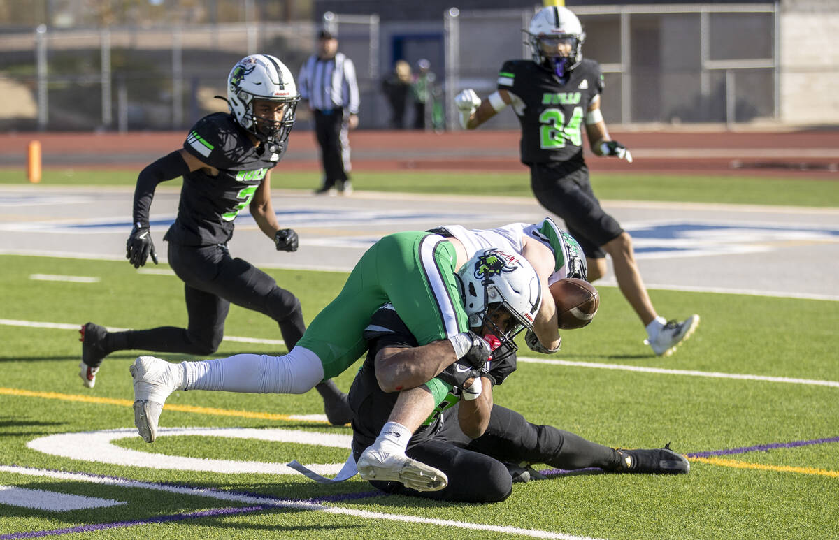 SLAM Academy senior Damien Nevil, bottom, tackles Churchill County junior Carson Melendy, top, ...