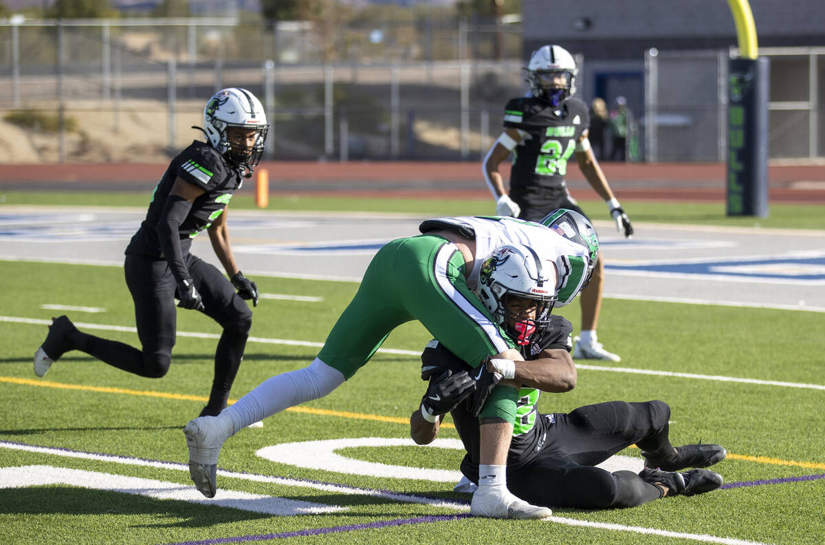 SLAM Academy senior Damien Nevil, bottom, tackles Churchill County junior Carson Melendy, top, ...