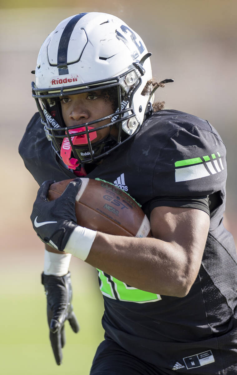 SLAM Academy senior Damien Nevil (12) runs with the ball during the 3A state semifinal football ...