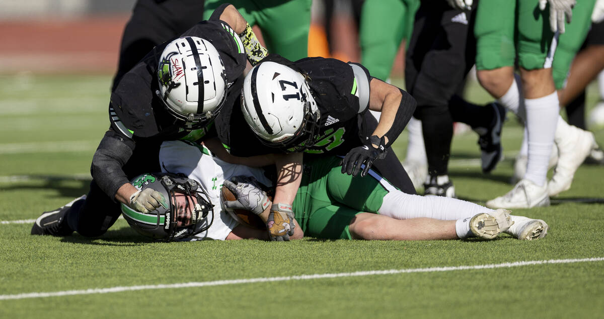 SLAM Academy linebacker Kyler Proudfoot, left, and senior Dylan Tondreau, right, pile on top of ...