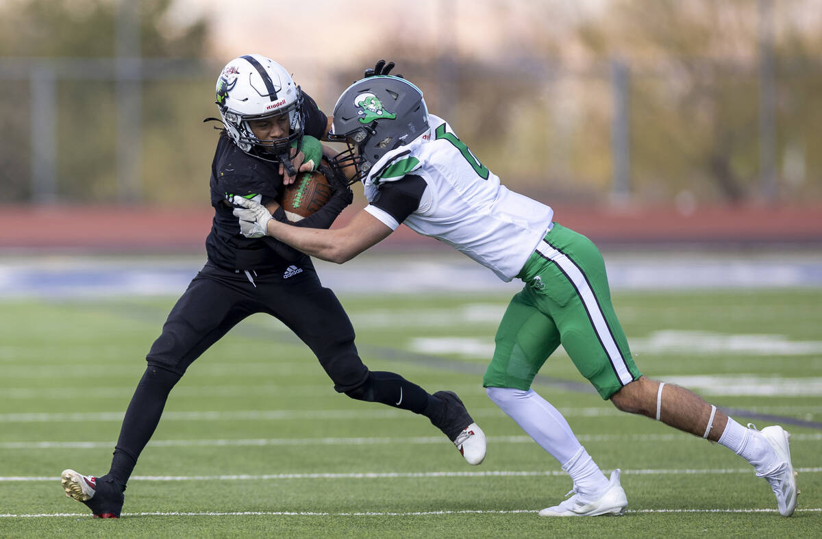 SLAM Academy senior Choy'ce Meloncon, left, is pushed by Churchill County junior Brenan Alves, ...