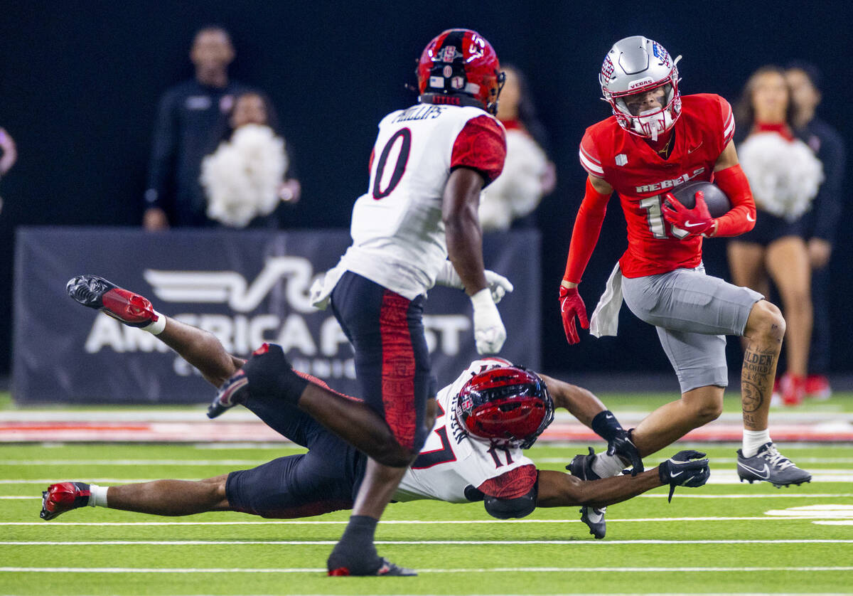 UNLV wide receiver Kayden McGee (16) escapes a tackle on a run by San Diego State Aztecs safety ...