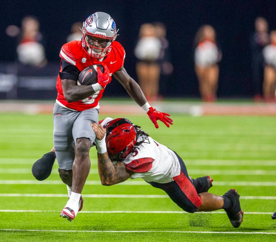 UNLV running back Jai'Den Thomas (9) pulls away from a tackle attempt by San Diego State Aztecs ...