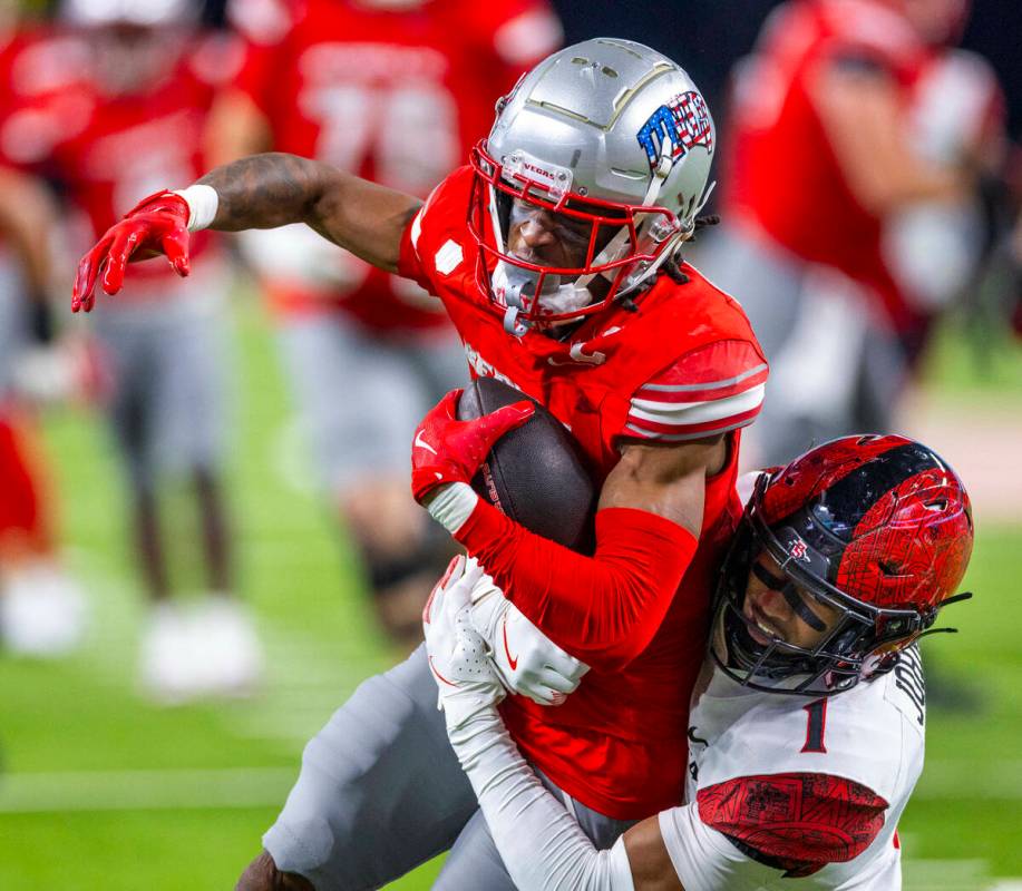 UNLV wide receiver Ricky White III (11) is wrapped up after a catch by San Diego State Aztecs s ...