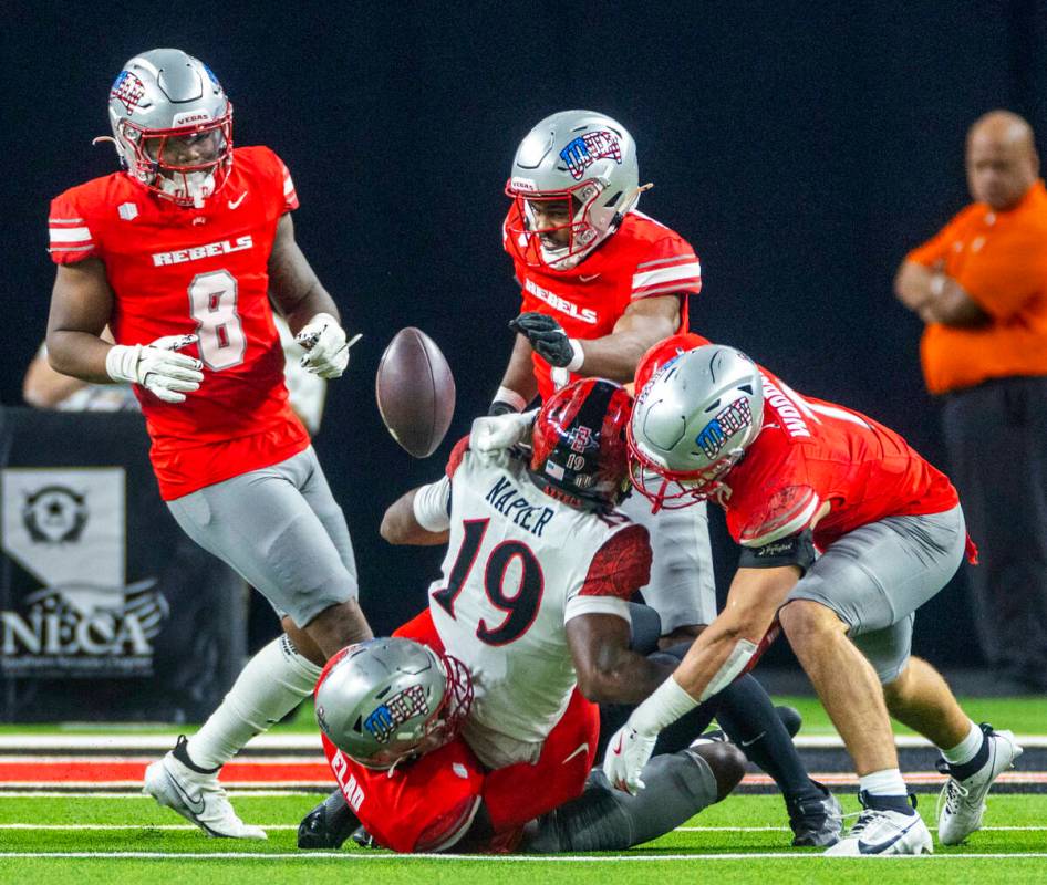 UNLV linebacker Jackson Woodard (7) jars the ball loose from San Diego State Aztecs wide receiv ...