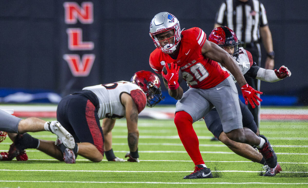 UNLV running back Kylin James (20) cuts upfield for more yards as he gets past San Diego State ...