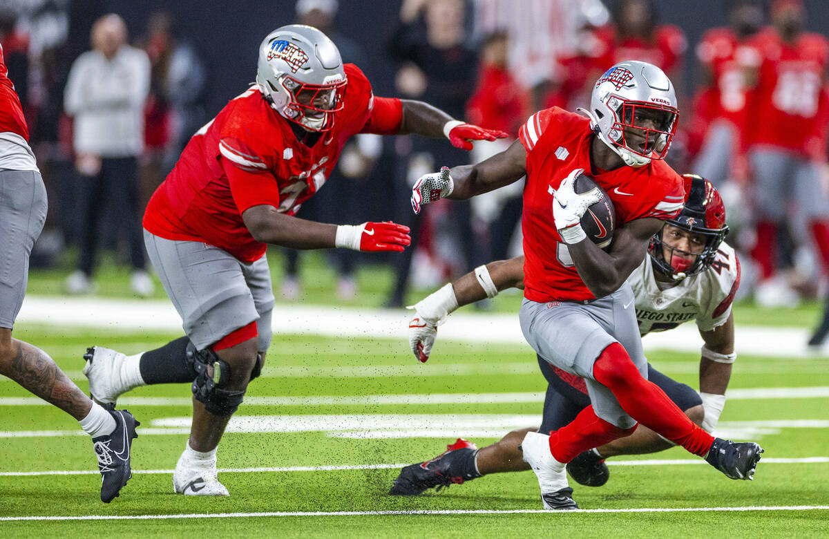 UNLV running back Greg Burrell (5) puts a move on San Diego State Aztecs edge Trey White (47) ...