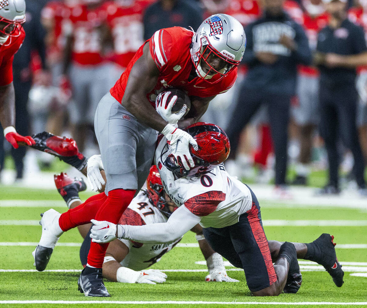 UNLV running back Greg Burrell (5) puts a move on San Diego State Aztecs edge Trey White (47) p ...