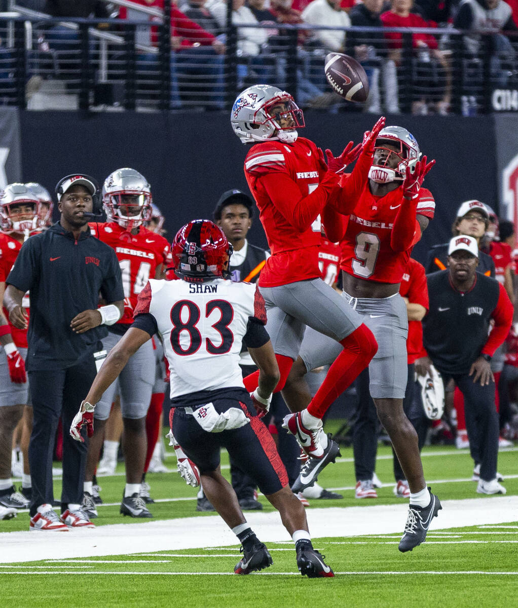 UNLV defensive back Cameron Oliver (5) and defensive back Jett Elad (9) team up for an intercep ...