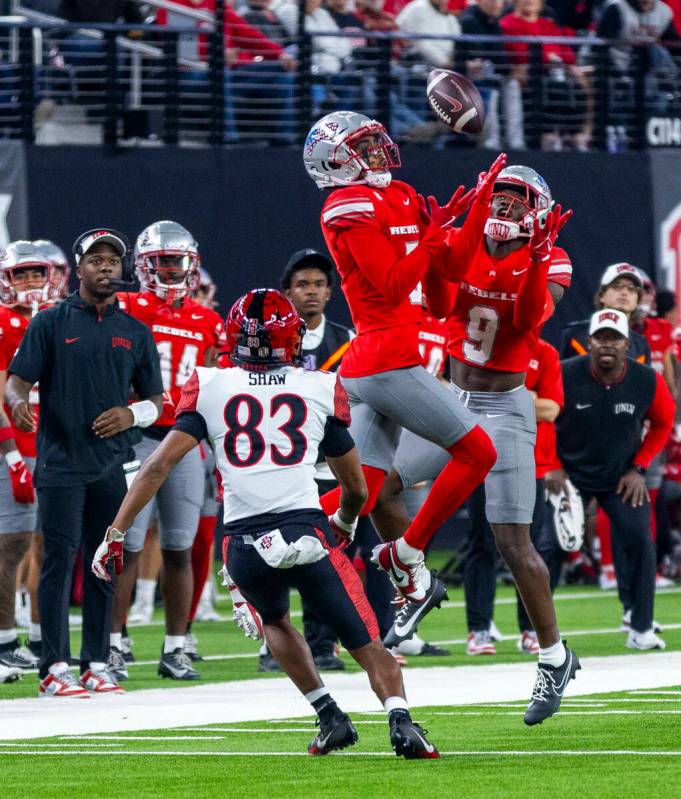 UNLV defensive back Cameron Oliver (5) and defensive back Jett Elad (9) team up for an intercep ...