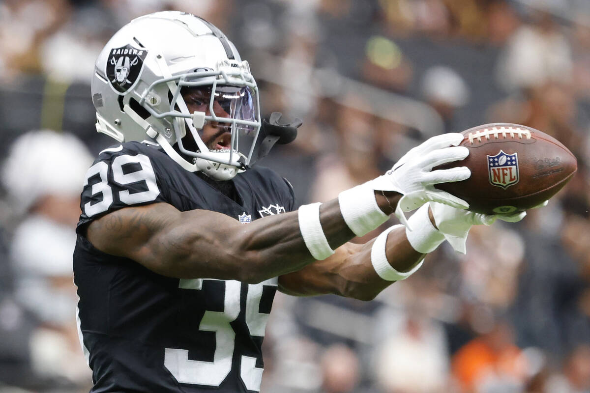 Raiders cornerback Nate Hobbs (39) catches the ball as he warms up before an NFL game against ...