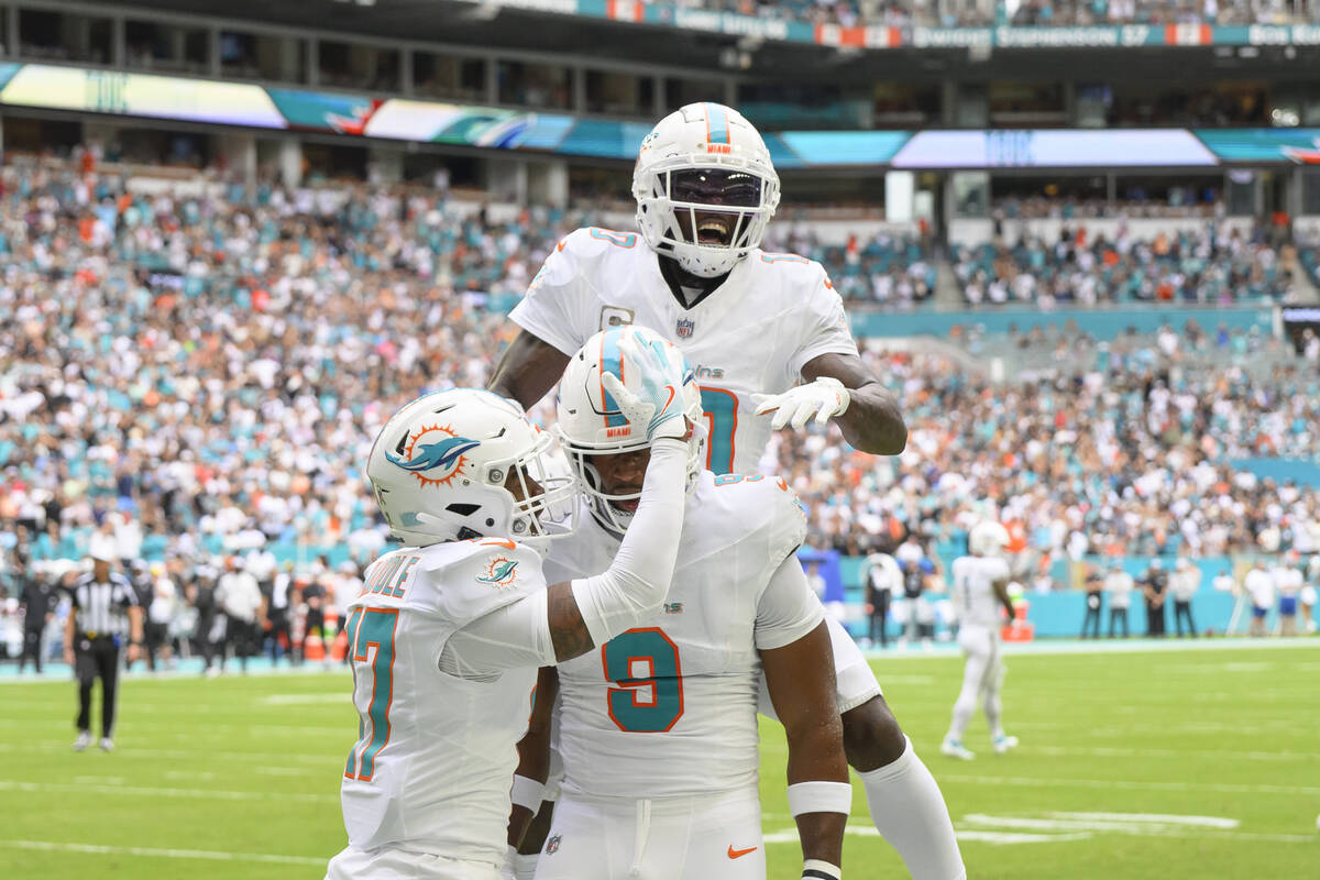 Miami Dolphins wide receiver Tyreek Hill (10) jumps on top of tight end Jonnu Smith (9) as Hill ...