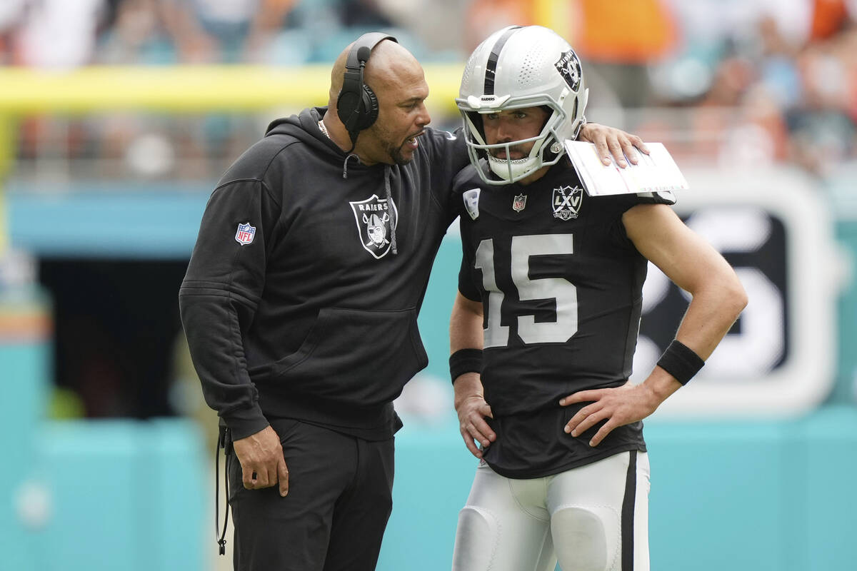 Las Vegas Raiders head coach Antonio Pierce talks to quarterback Gardner Minshew (15) during th ...