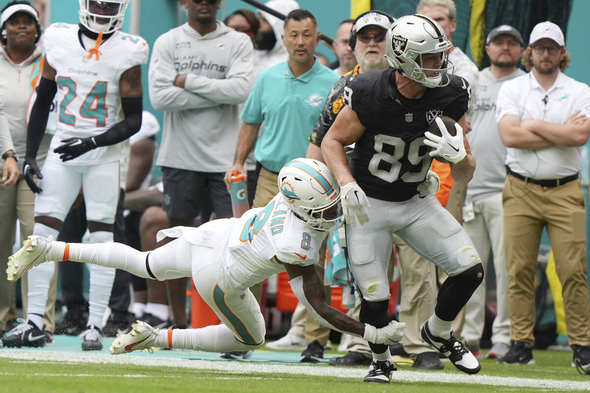 Miami Dolphins safety Jevon Holland (8) grabs Las Vegas Raiders tight end Brock Bowers (89) dur ...