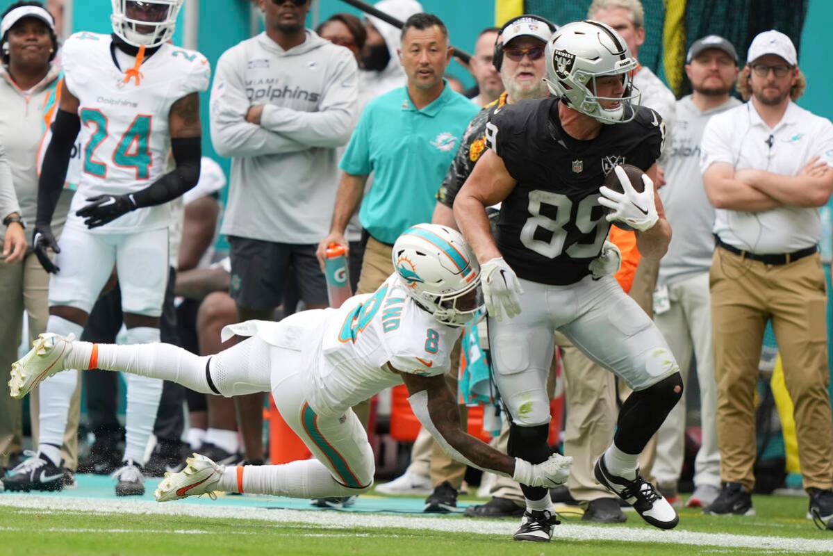 Miami Dolphins safety Jevon Holland (8) grabs Las Vegas Raiders tight end Brock Bowers (89) dur ...