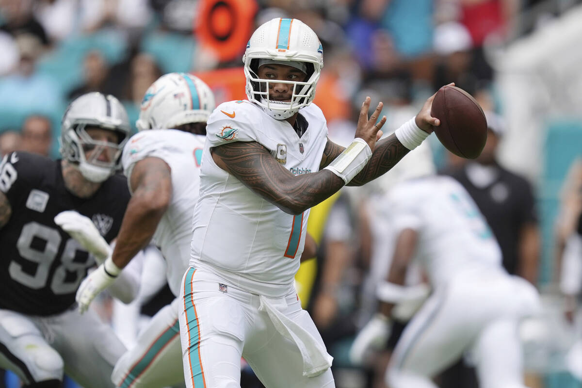 Miami Dolphins quarterback Tua Tagovailoa (1) aims a pass during the first half of an NFL footb ...