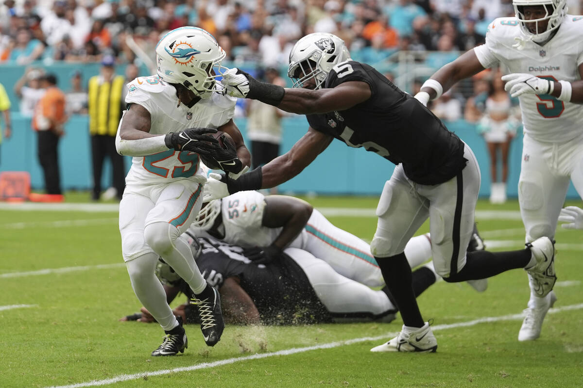 Las Vegas Raiders linebacker Divine Deablo (5) grabs Miami Dolphins running back Jaylen Wright' ...