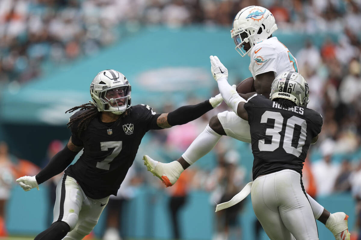 Miami Dolphins wide receiver Tyreek Hill (10) catches a pass in between Las Vegas Raiders safet ...