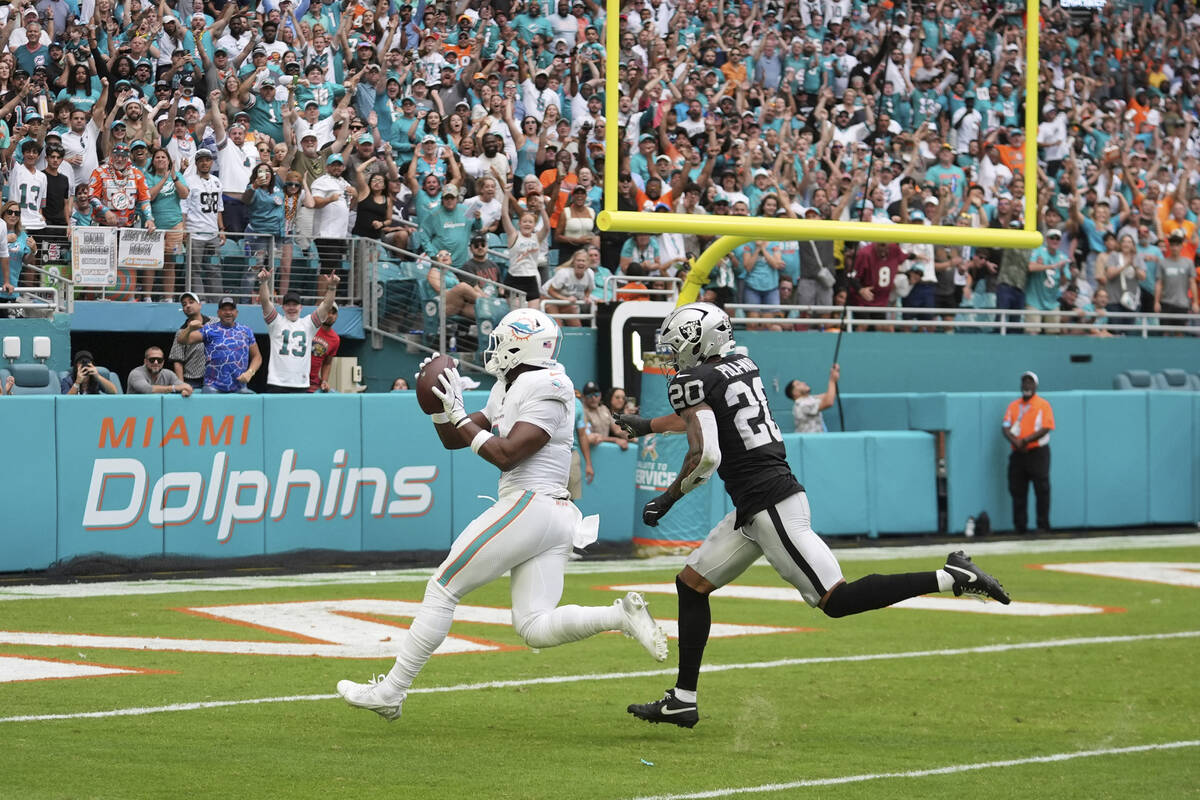 Miami Dolphins tight end Jonnu Smith (9) scores a touchdown as Las Vegas Raiders safety Isaiah ...