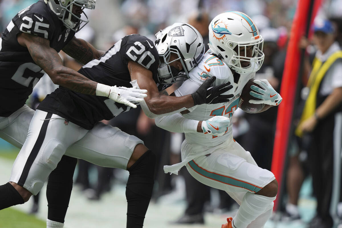 Las Vegas Raiders safety Isaiah Pola-Mao (20) tackles Miami Dolphins wide receiver Jaylen Waddl ...