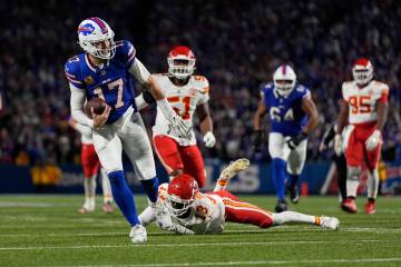 Buffalo Bills quarterback Josh Allen (17) slips past Kansas City Chiefs cornerback Nazeeh Johns ...