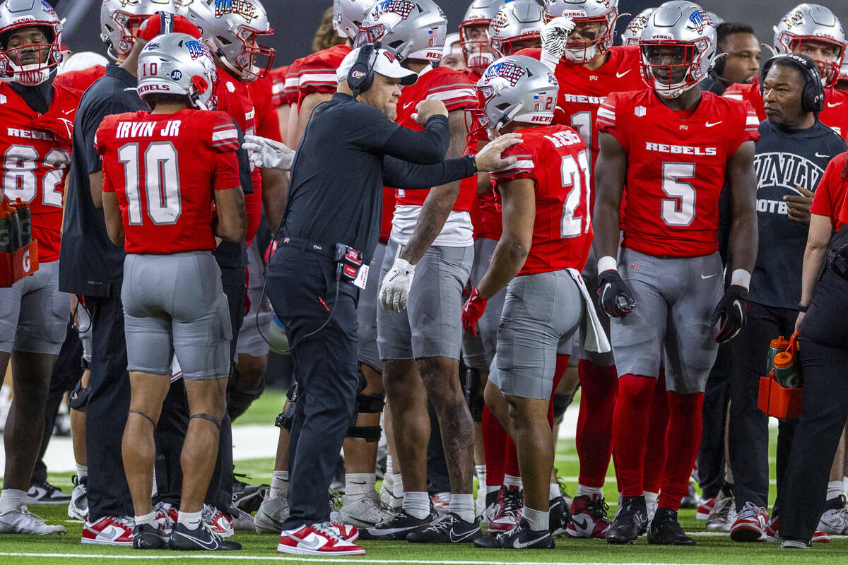 UNLV head coach Barry Odom congratulates UNLV wide receiver Jacob De Jesus (21) on a return aga ...