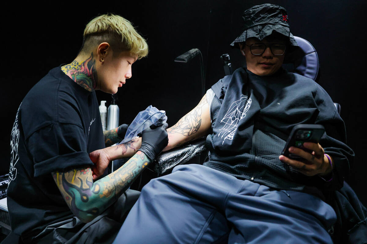 Joshua Lin, a popular tattoo artist, left, tattoos Eric Lai during ComplexCon at the Las Vegas ...