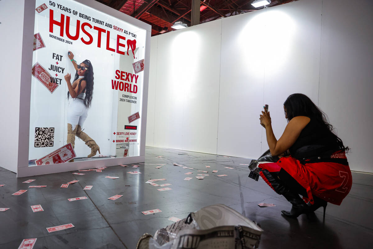 Kimberly Ellis, right, takes a photograph of her friend, Asia, at a Sexyy Red booth during Comp ...