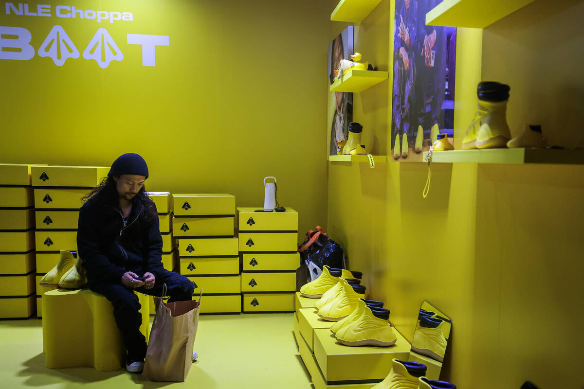 An attendee checks their phone inside a shopping booth during ComplexCon at the Las Vegas Conve ...