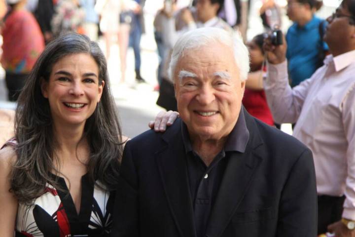 Arthur Frommer, 83, and his daughter, Pauline Frommer, 46, pose among tourists in the Wall Stre ...