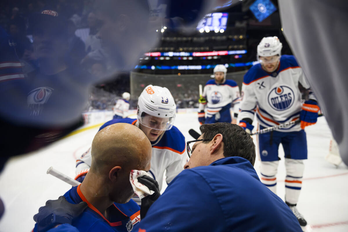 Edmonton Oilers defenseman Darnell Nurse (25) is attended to by medical personnel and teammates ...