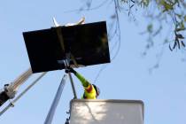 A worker from Clark County’s Public Works Department installs one of the 12 new solar streetl ...