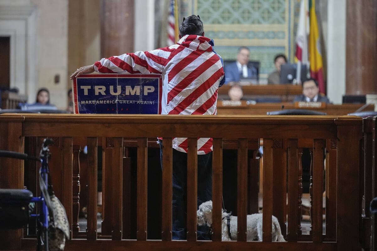 Protestor Herman Armando displays a Pro Trump sign during his public comment time, as members w ...