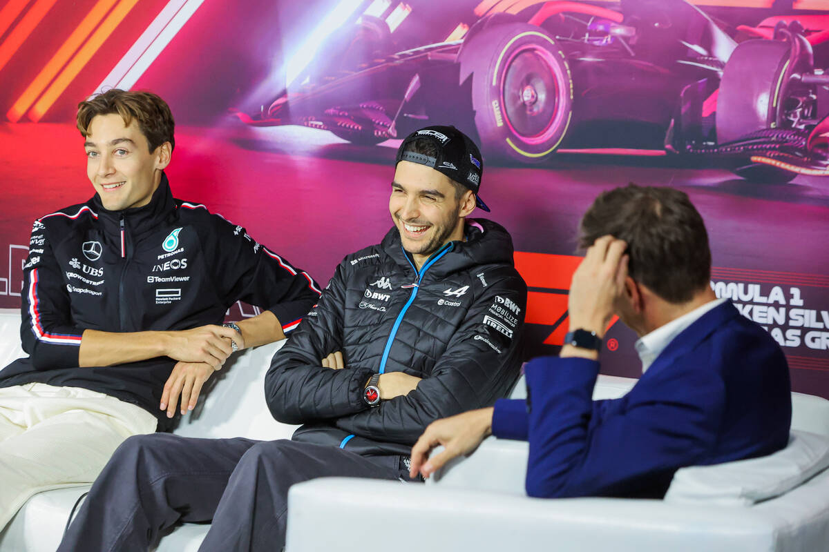 Formula 1 drivers Esteban Ocon, middle, and George Russell share a laugh during a Formula 1 pre ...