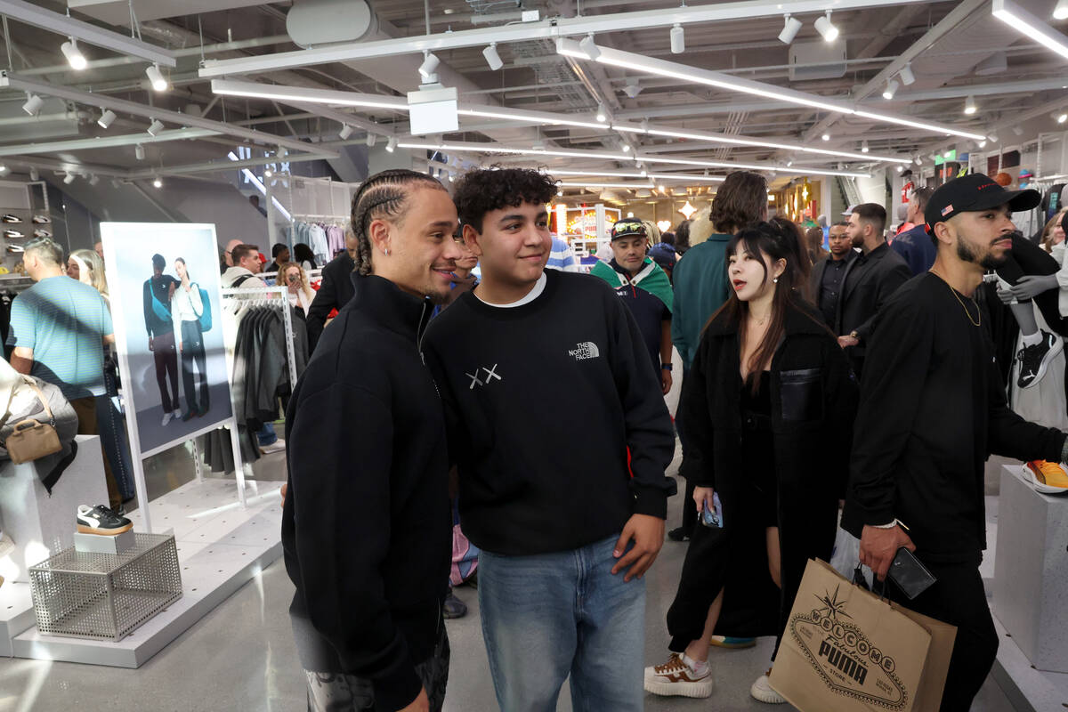 Xavi Simons, PUMA Athlete (Soccer), left, poses with a fan during the grand opening of PUMA on ...