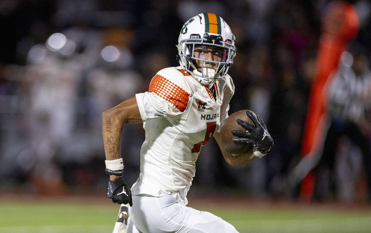 Mojave senior Peyton Parnell (8) looks back before taking the ball to the end zone during the h ...