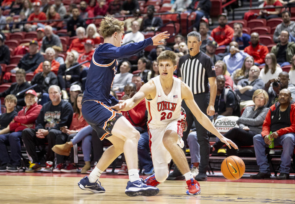 UNLV guard Julian Rishwain (20) attempts to juke out Pepperdine Waves guard Jaxon Olvera, left, ...