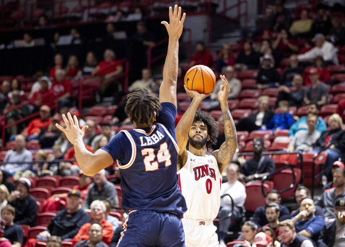 UNLV forward Isaiah Cottrell (0) attempts a three-point shot over Pepperdine Waves center Alex ...