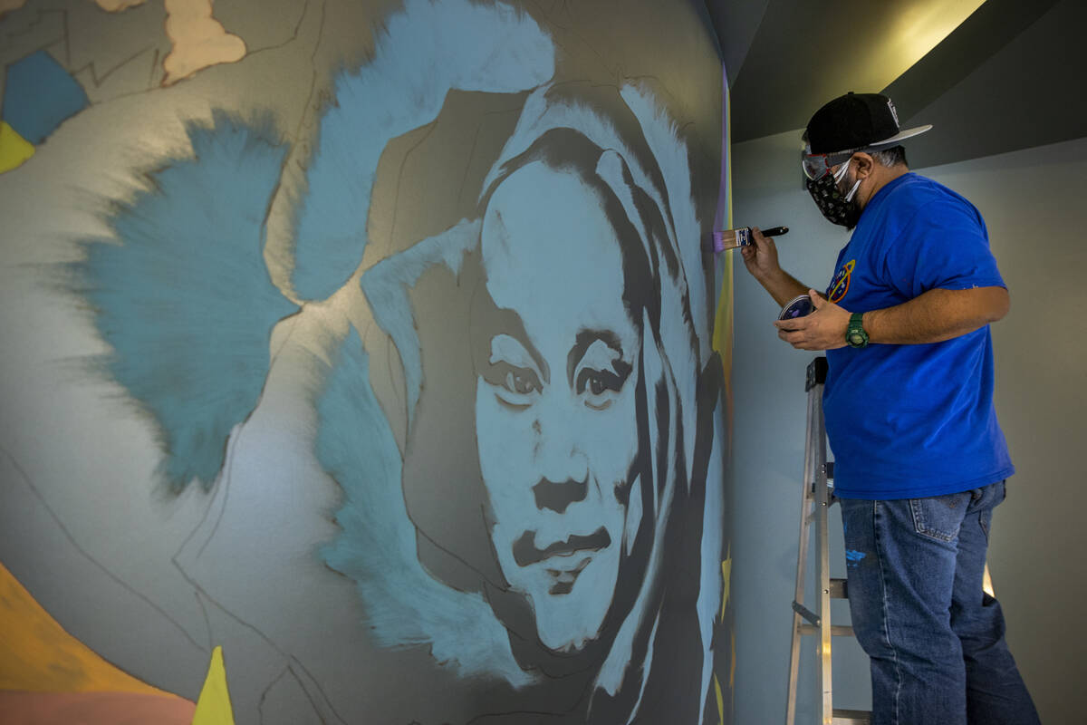 Artist Miguel Hernandez paints a mural in memory of Tony Hsieh in the lobby of ART HOUZ Theater ...