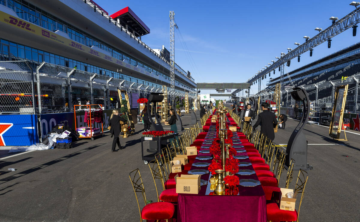 Servers and other contractors continue to set of tables for a pre-race dining experience on the ...