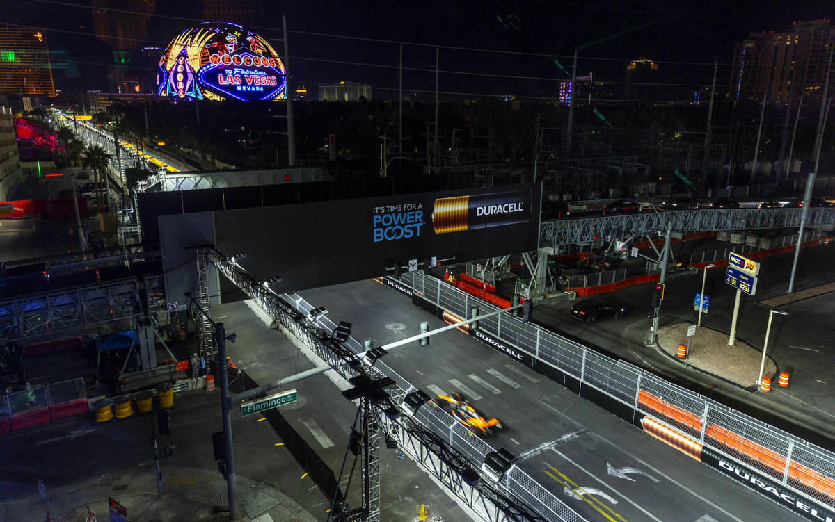 A race car navigates up the track along Koval Lane during the Formula One opening practice sess ...