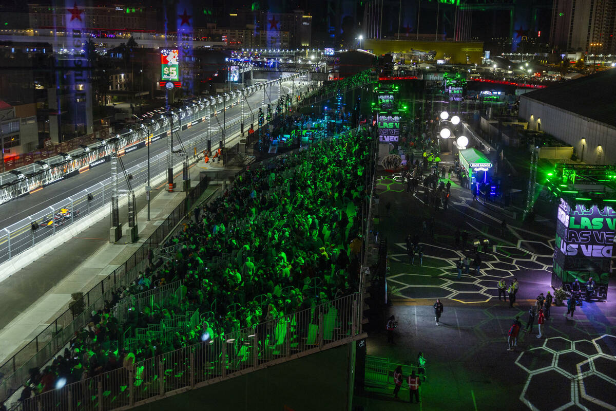 People watch the cars navigate the track below the Heineken tower during the Formula One openin ...