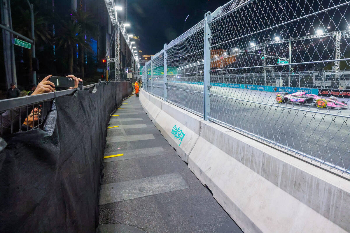 Formula 1 fans sneak photos over the barriers during Formula 1 opening practice ahead of the Fo ...