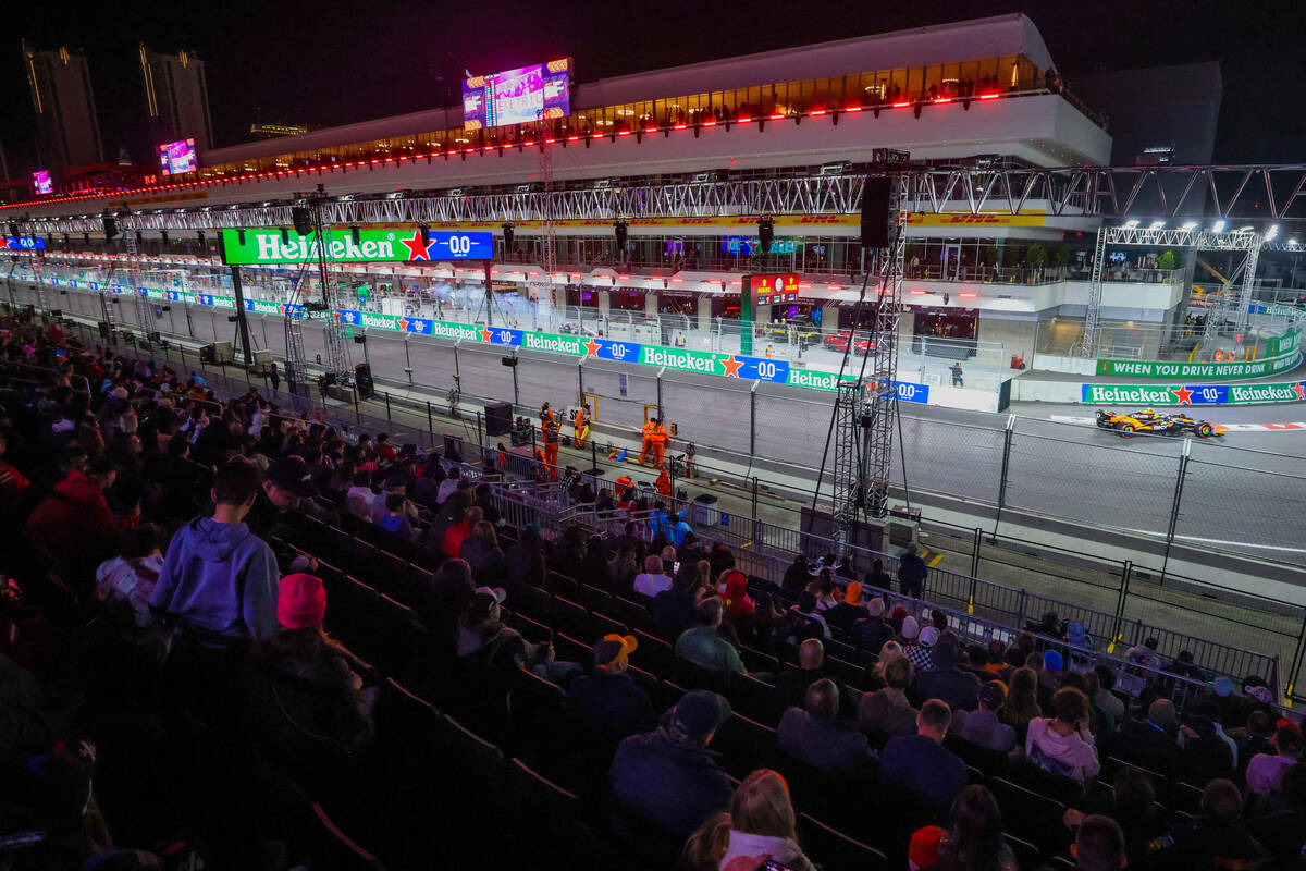 Fans sit in the grandstands as drivers zoom by during Formula 1 opening practice ahead of the F ...